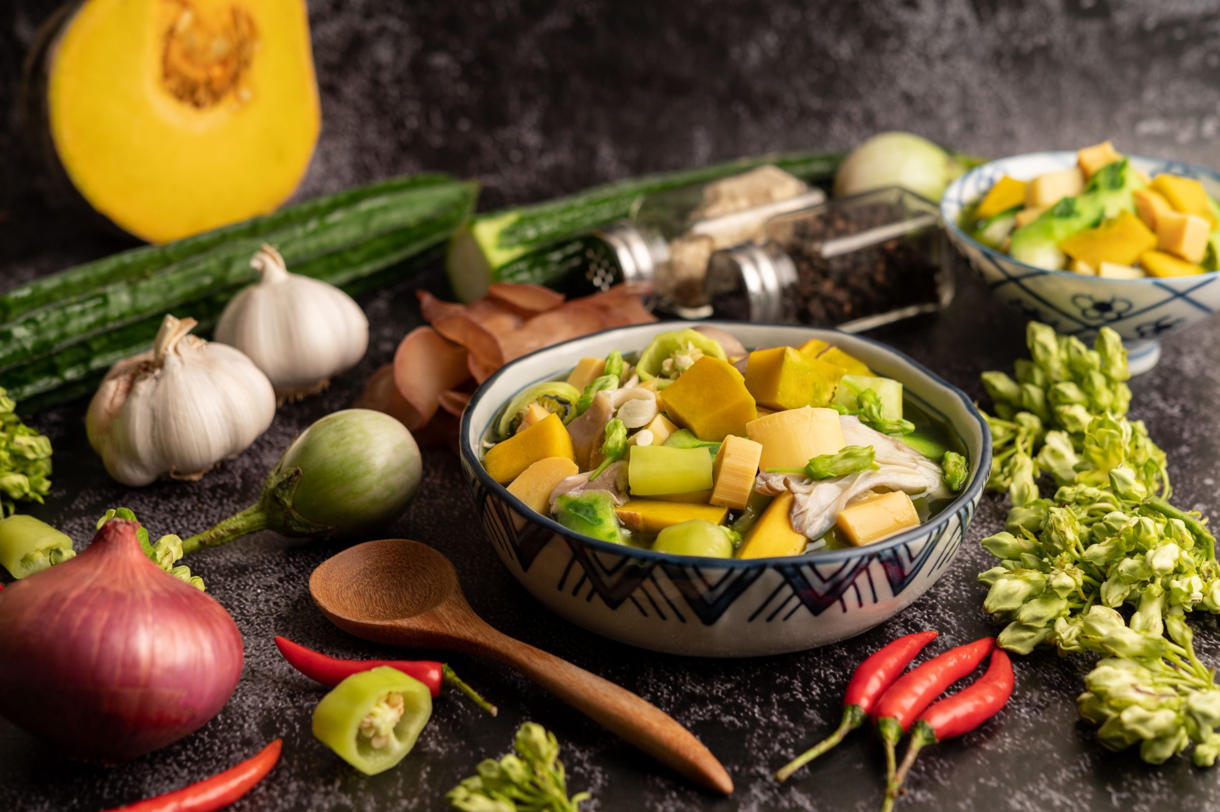 kaeng-liang-in-a-bowl-with-spices-on-a-black-cement-floor